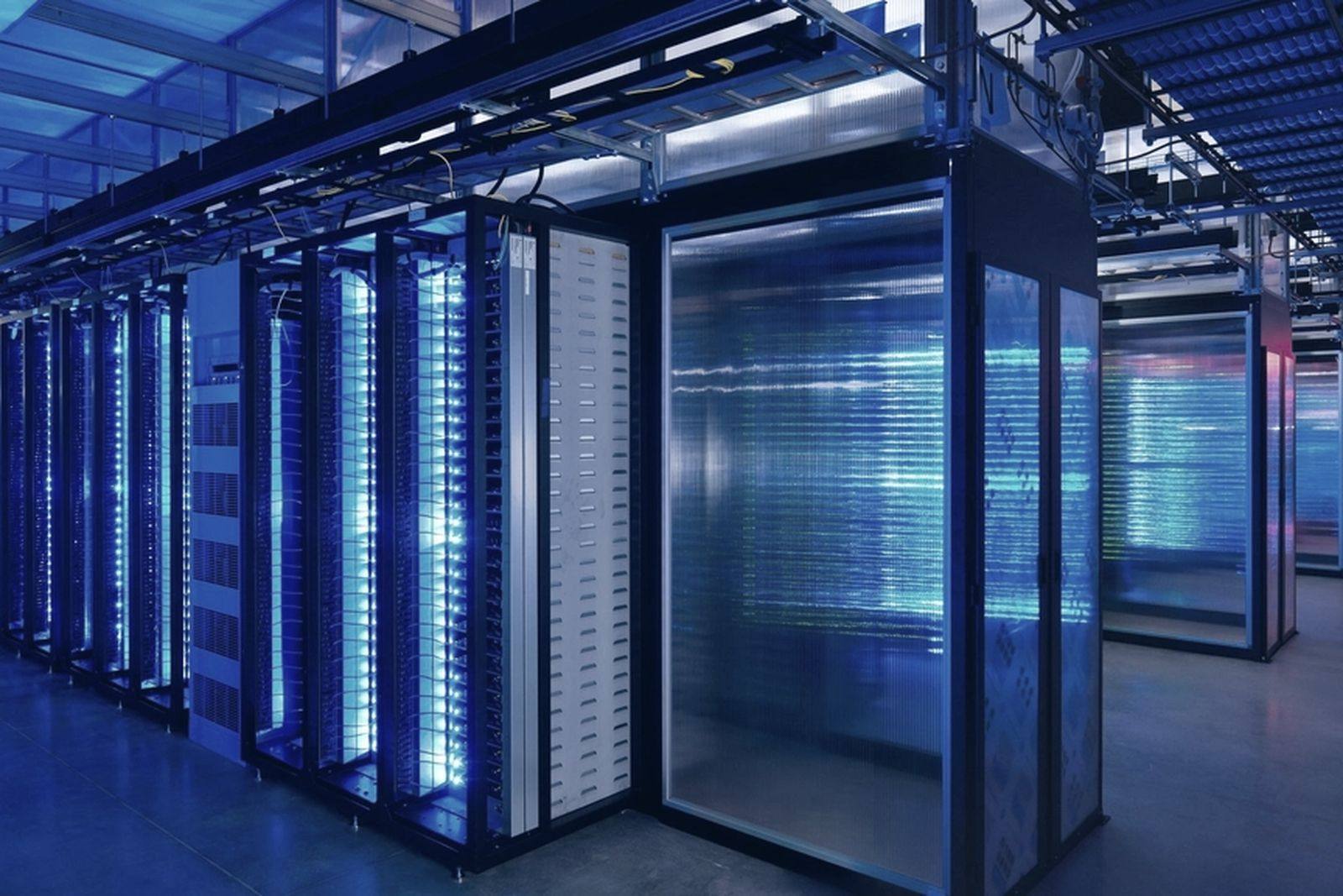 A lit data centre aisle between rows of racks
